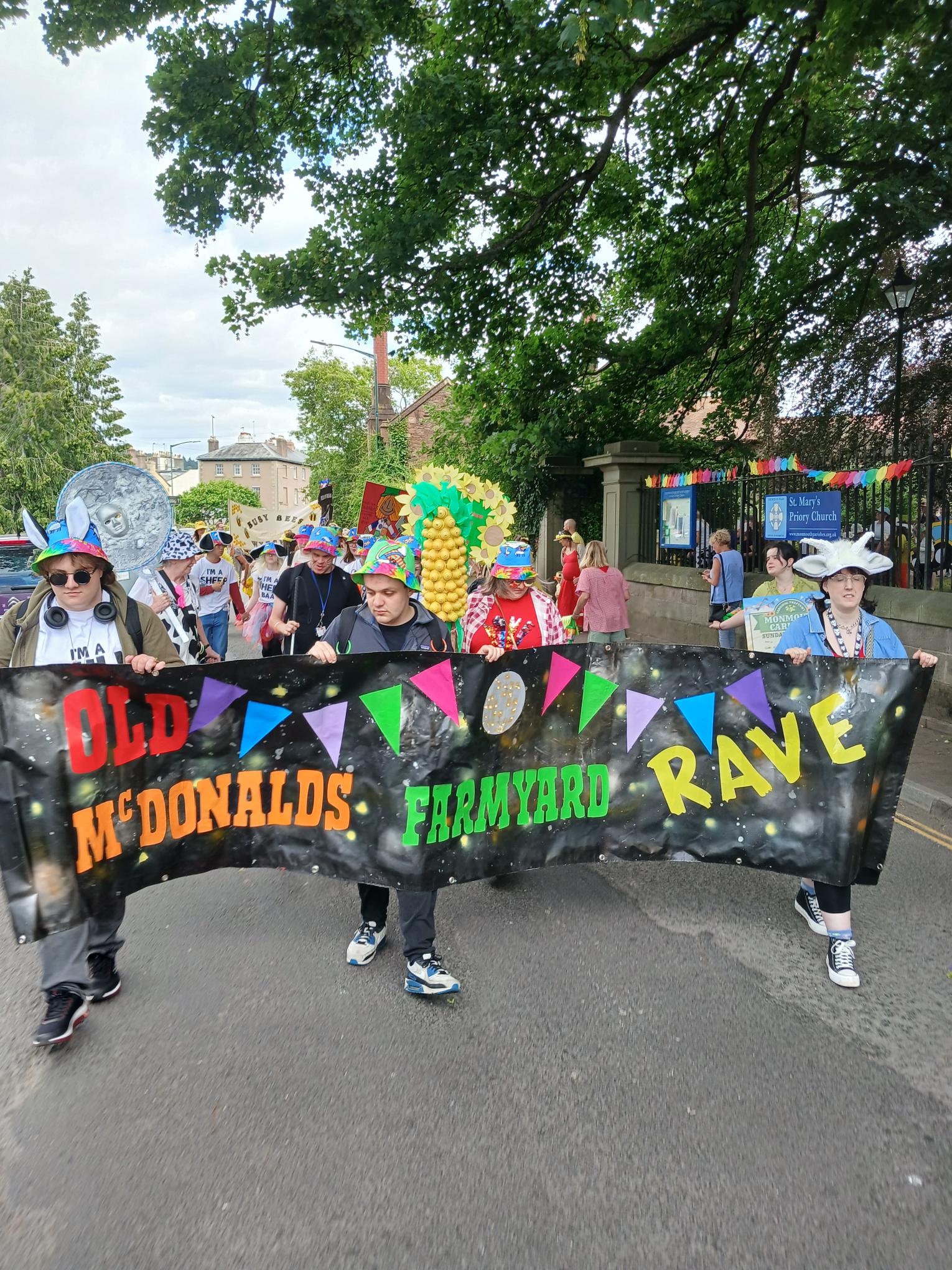 The group walking through the Monmouth streets the front 3 hold up a banner 