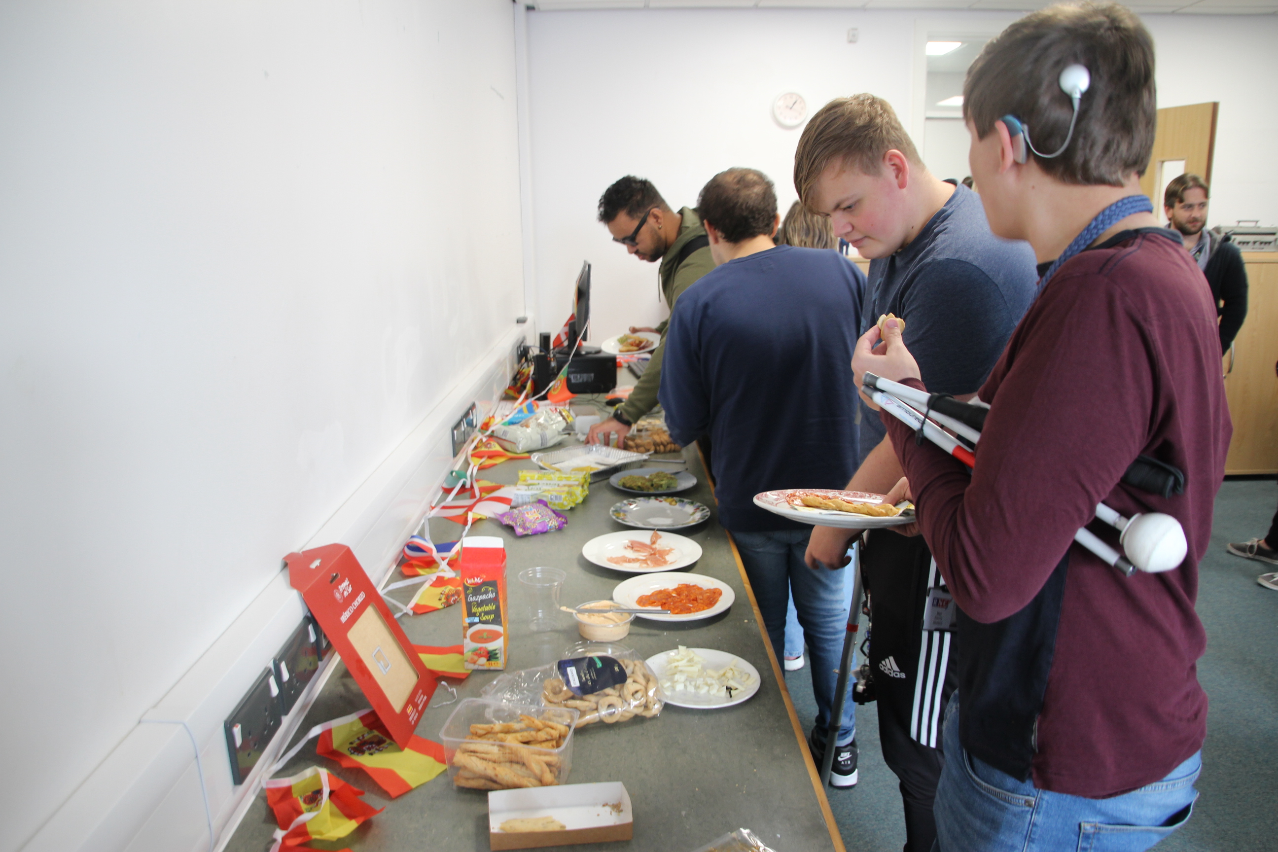 guest lining up in front of a work surface covered in plates and packets of different foods