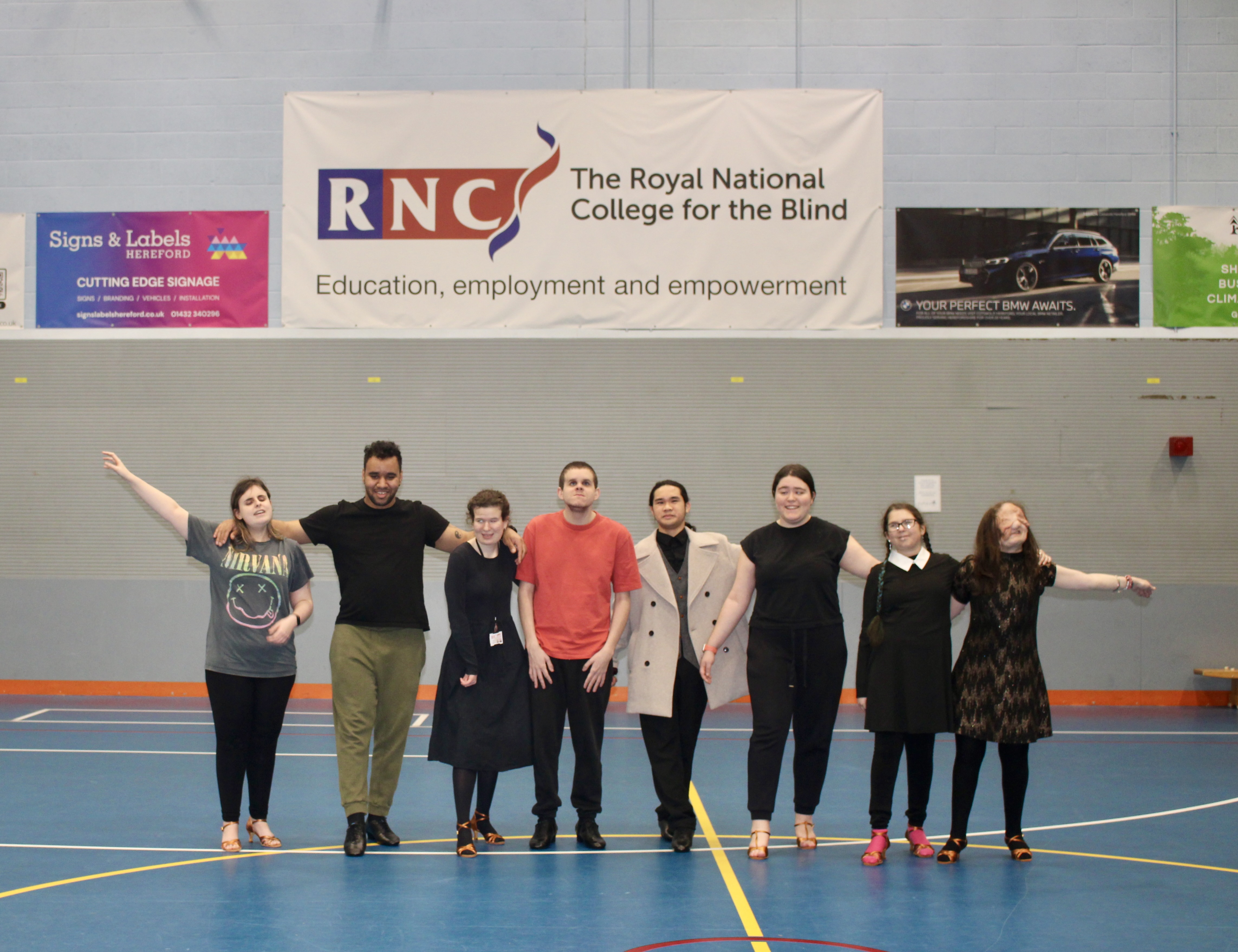 students stand in a line with their right foot forward in a dance pose