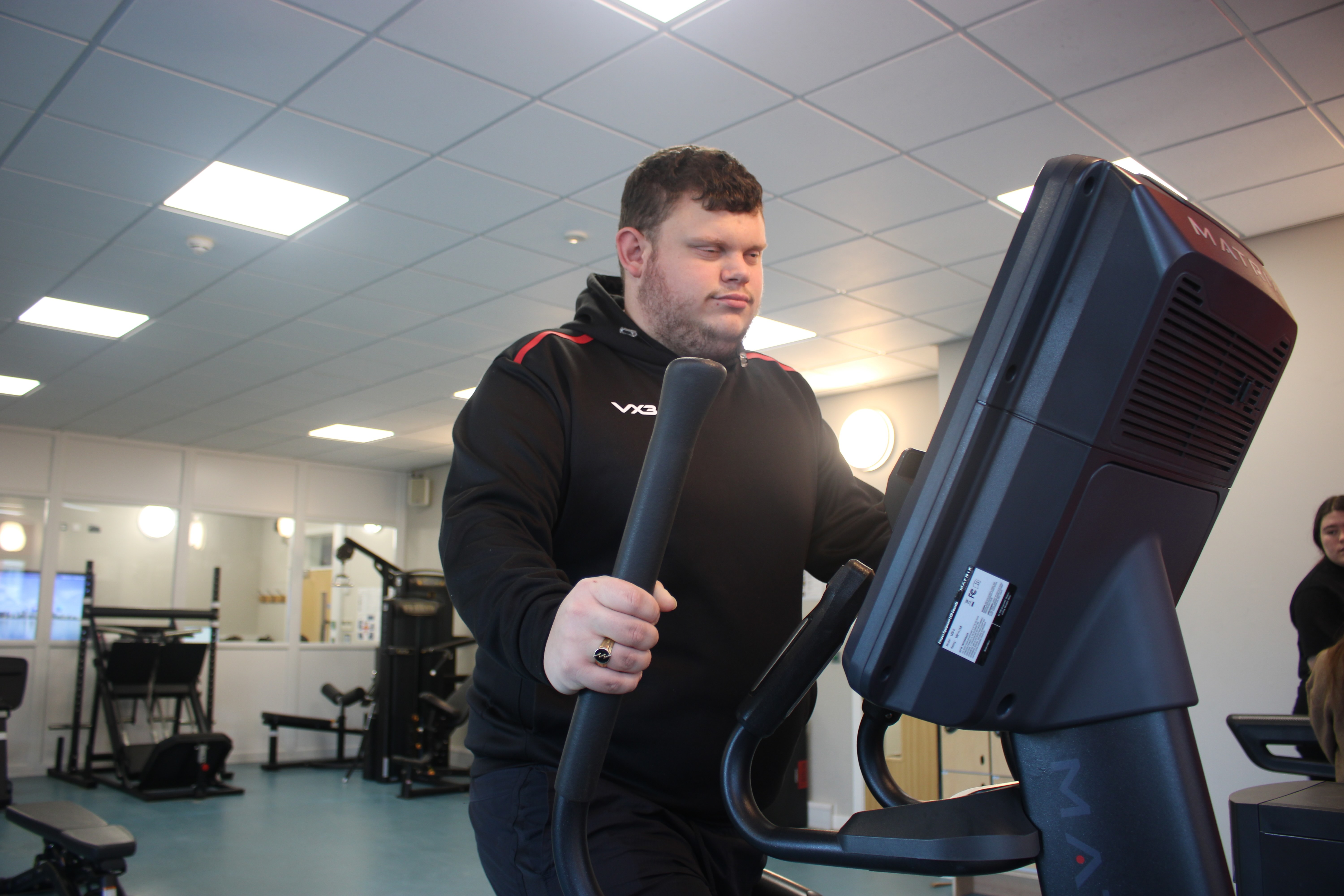 Kyron working out on the cross trainer in RNC's student gym
